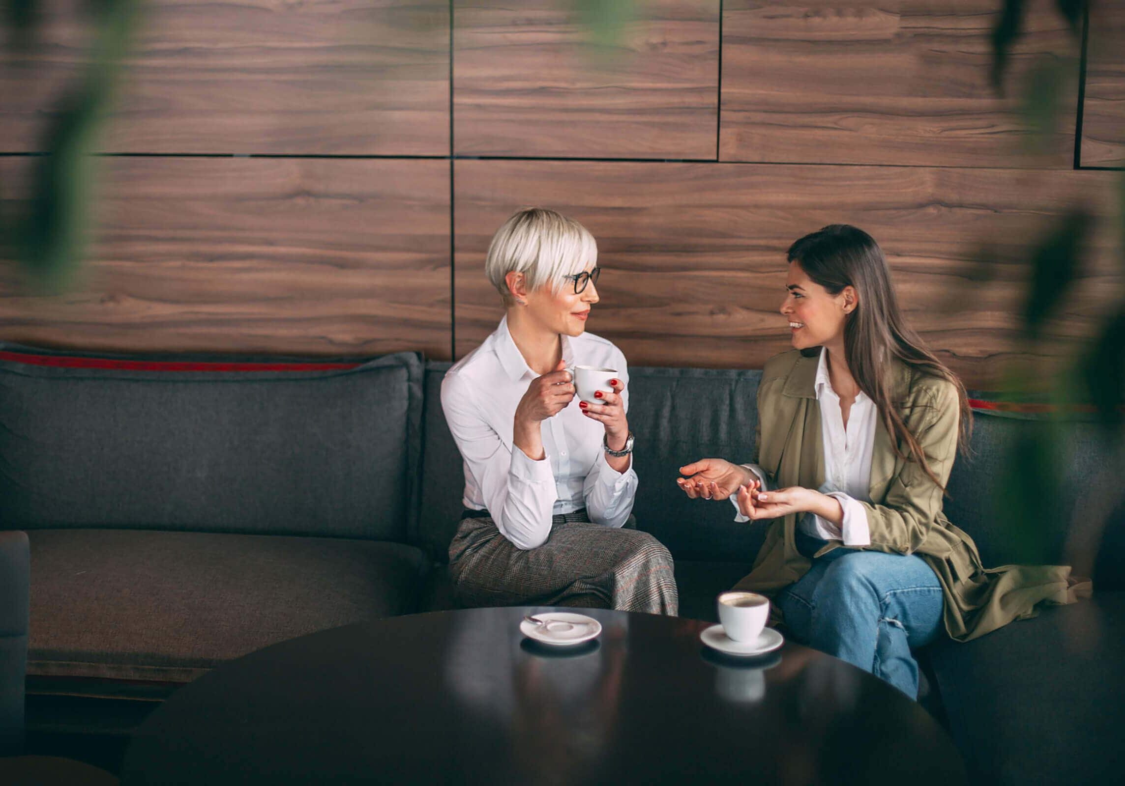 Coaching Session over Coffee Two women having a coaching session over coffee in a modern lounge.