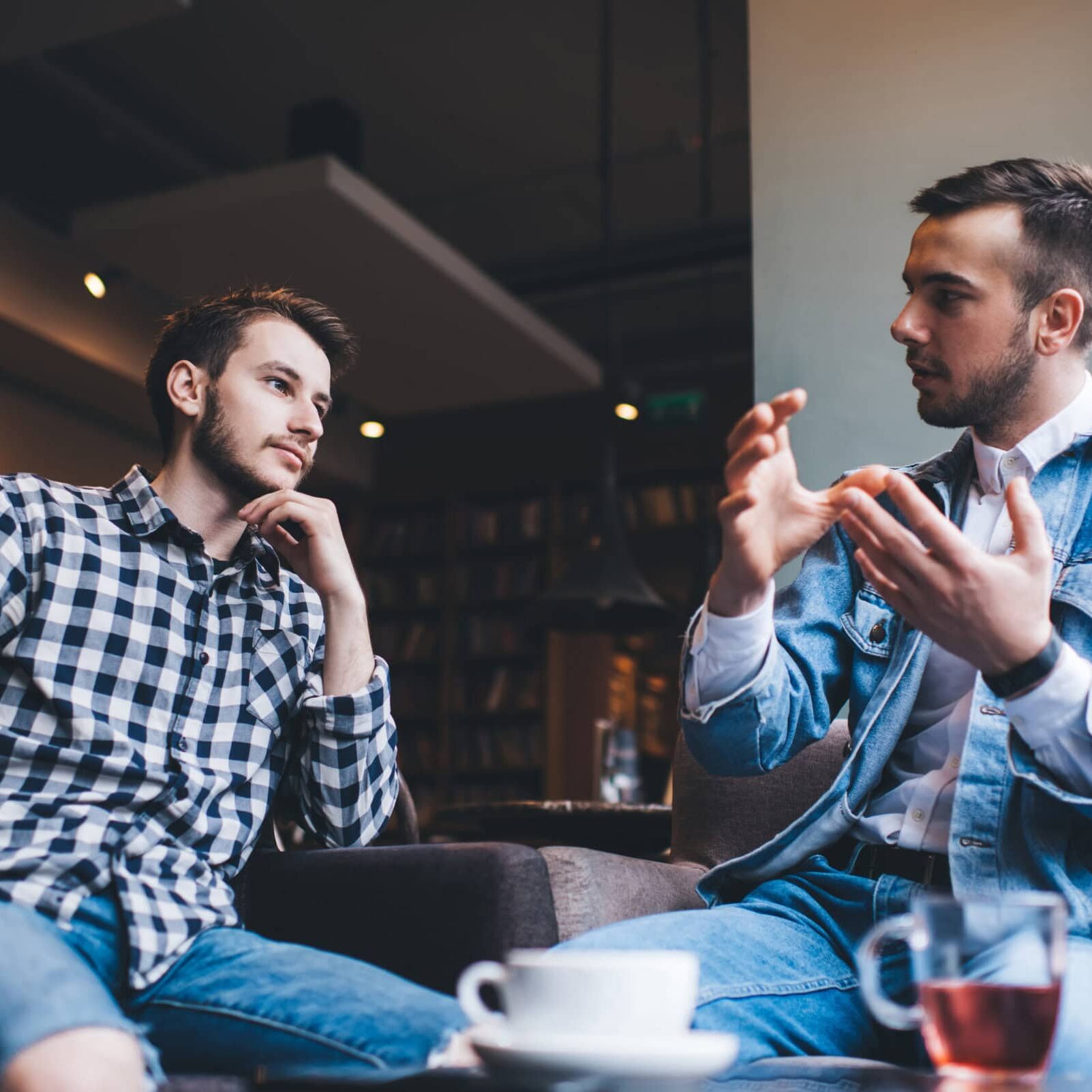 Serious adult males friends talking together in cafe Coaches networking at an ICF chapter event